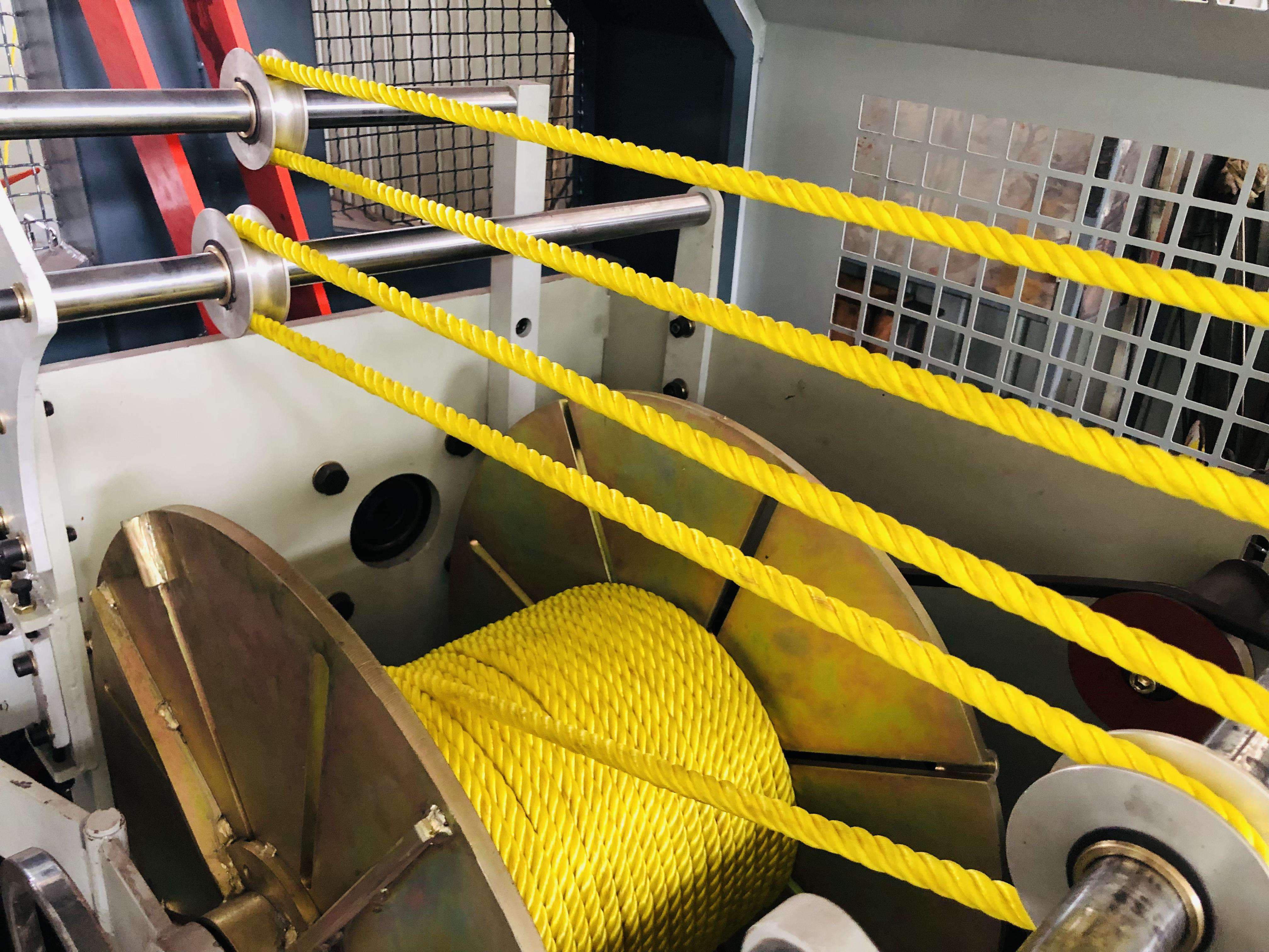 Yellow rope passing through manufacturing machinery